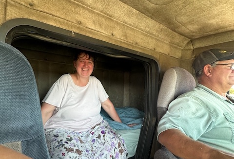 Sibllings in semi-truck hauling corn to the elevator during fall harvest