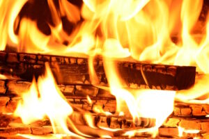 homestead fire safety tips - logs burning with bright orange flames and glowing embers